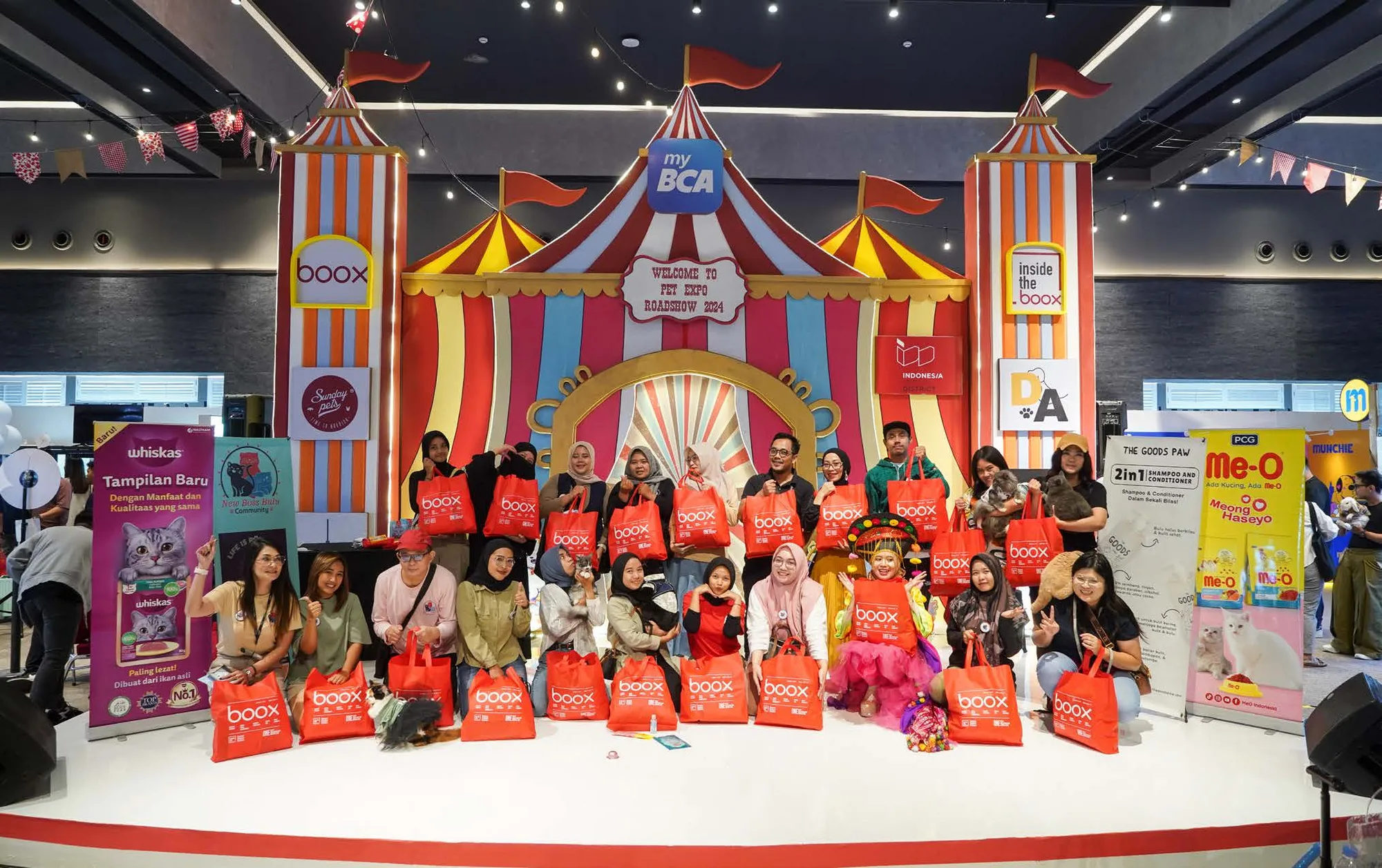 Instalasi tenda sirkus Pet Expo Roadshow 2024 dengan logo BOOX dan myBCA, pengunjung berbaris memegang tote bag BOOX